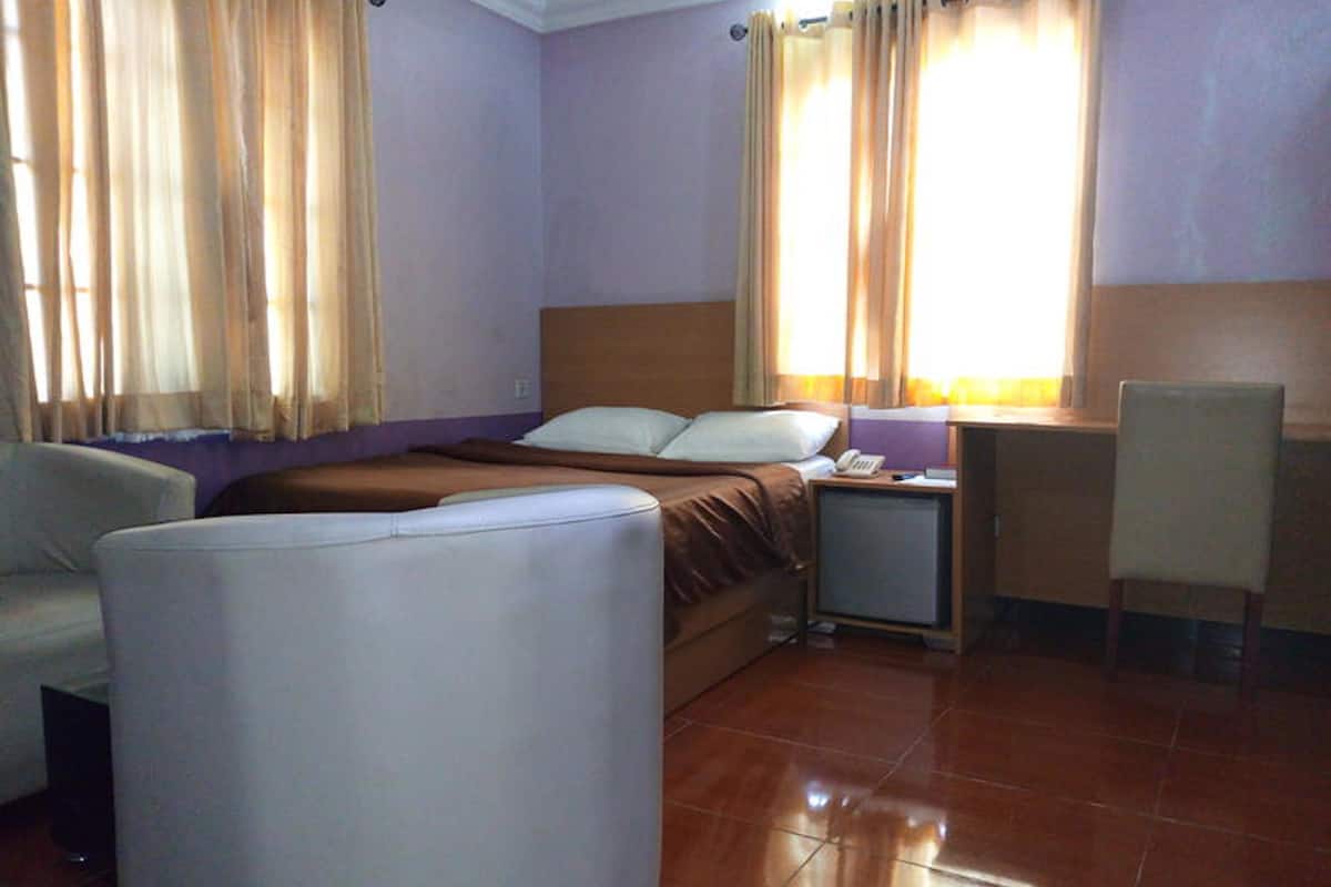 Ein Hotelzimmer mit Bett, Schreibtisch, Stuhl und Sofa.