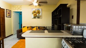 A compact kitchen with a central island, a microwave, and a stove. - New Kingston Most Central Guest Apt (Kingston)