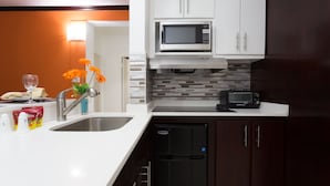 A modern kitchen with white cabinets, a microwave, a toaster, and a refrigerator. - New Kingston Premium Guest Apartment (Kingston)