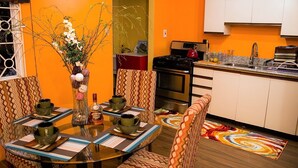 A dining area with a round table, patterned chairs, and a vase with flowers. - New Kingston Guest Apt at The Stadium (Kingston)