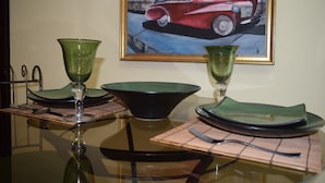 Een eettafel met groen glaswerk, borden en bestek.
