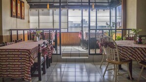 A restaurant with tables covered in patterned tablecloths, chairs, and hanging pendant lights. - Hotel Durango (Durango)