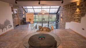 An interior with a glass table, a sculpture, and a view through a skylight. - The Peacock at Barlow (Dronfield)
