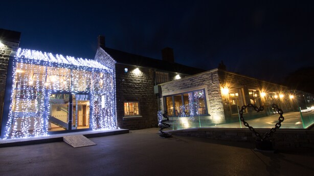 A building with illuminated windows and a heart-shaped sculpture. - The Peacock at Barlow (Dronfield)