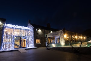 A building with illuminated windows and a heart-shaped sculpture.