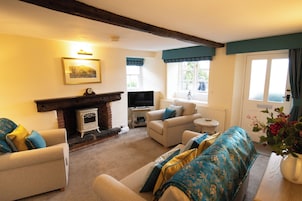 A cozy living room with a fireplace, comfortable seating, and a television.