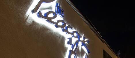 A building with a neon sign that reads "The Peacock Hotel."
