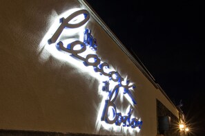 A building with a neon sign that reads "The Peacock Hotel." - The Peacock at Barlow (Dronfield)