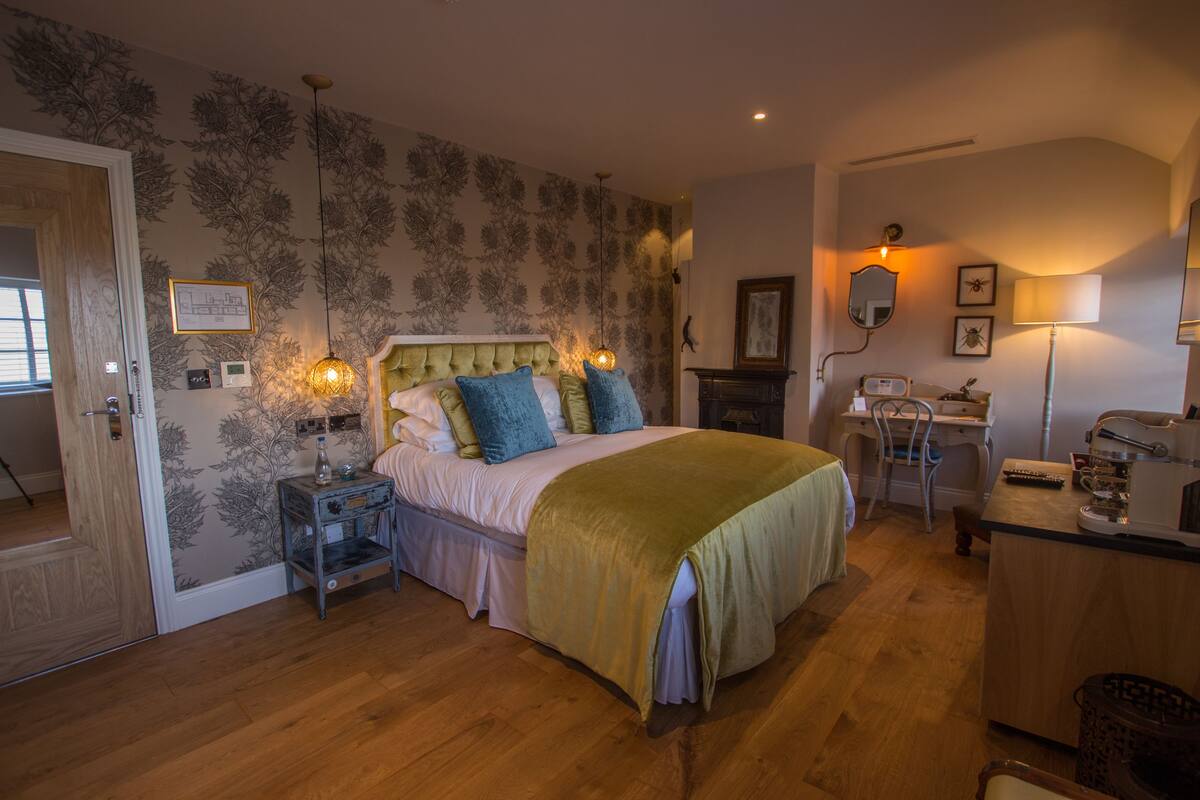 A bedroom with a bed, bedside tables, a desk, and a chair.
