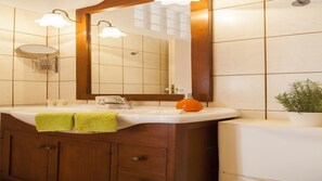 Superior appartement | Badkamer | Een douche, een haardroger, handdoeken