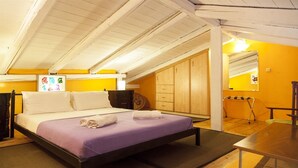 A room with a bed, wooden wardrobe, and a table. - Villa Kirki Apartments (Kefalonia)