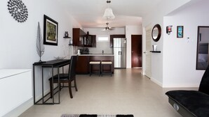 Una cucina moderna con zona pranzo, un divano nero e una ventola a soffitto.