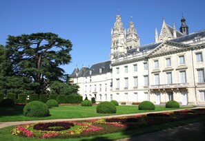 A large, historic building with symmetrical architecture, manicured gardens, and a prominent tree. - RIAD SPA Les portes de l'Orient TOURS (Tours)