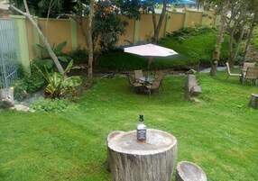 Un patio trasero con una mesa de madera, una botella de whisky Jack Daniel's y una sombrilla.