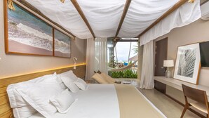 A hotel room with a bed, a desk, a chair, a painting, and a view of a beach and palm trees. - Flor de Lis Exclusive Hotel (Maceió)