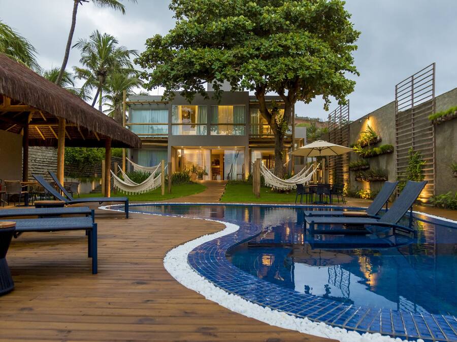 Una piscina al aire libre, sombrillas, sillones reclinables de piscina