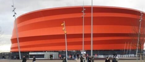 A large, circular, red stadium with multiple tiers of seating.