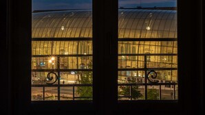 A view through a window of a modern building with a curved glass facade and a clock visible on the upper part. - ibis budget Strasbourg Centre Gare (Strasbourg)