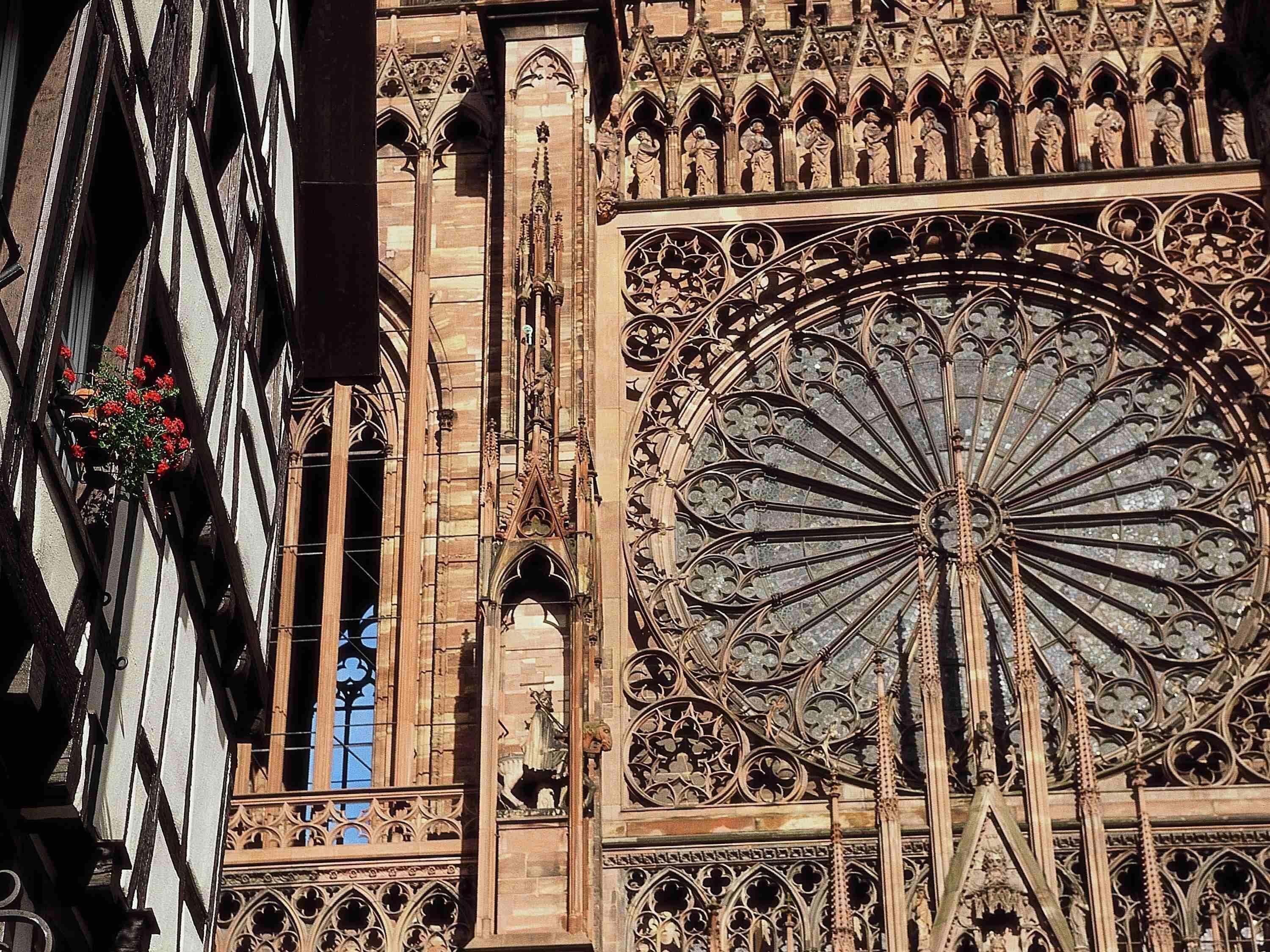 Ein Detailblick auf ein gotisches Fenster mit filigranem Zellwerk und einem großen Rosfenster.