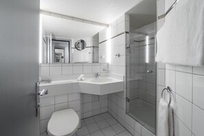 A modern bathroom with a toilet, sink, and shower. - Boutique Hotel Stockalperhof (Brig)