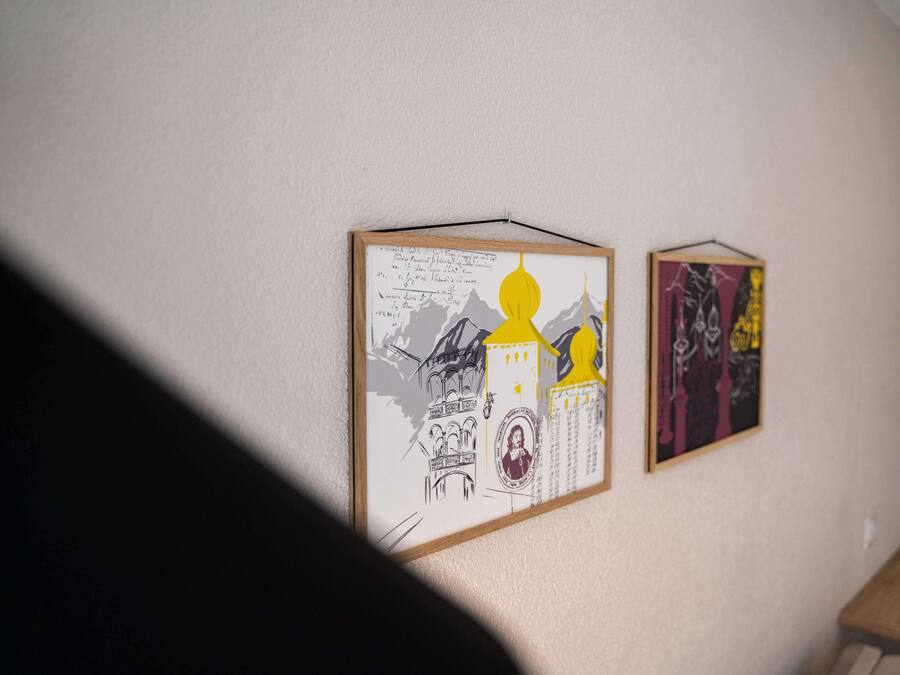 Deux œuvres d’art encadrées sont accrochées au mur.