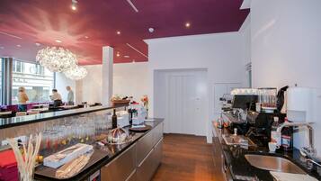 Una cocina moderna con una isla central, electrodomésticos de acero inoxidable y una zona de café.