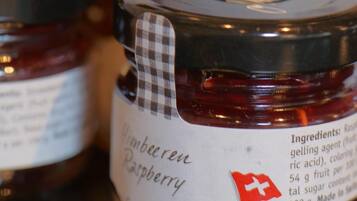 A close-up of several jars of raspberry jam with labels.