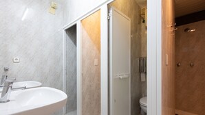 A bathroom with a white sink, a toilet, and a shower area. - Pensión Galicia (Canovelles)