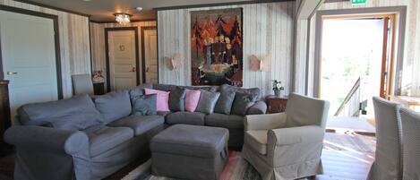 Ein Wohnzimmer mit einem Ecksofa, einem Sessel und einem Teppich.