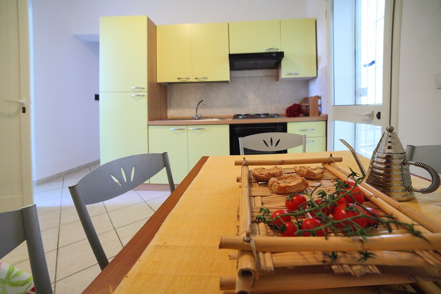 Een koelkast, een kookplaat, kookgerei, borden en bestek