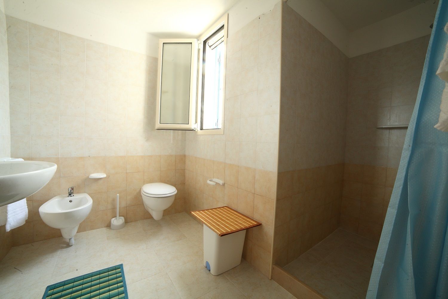Une salle de bain équipée d’un lavabo, d’un bidet, de toilettes et d’une douche.