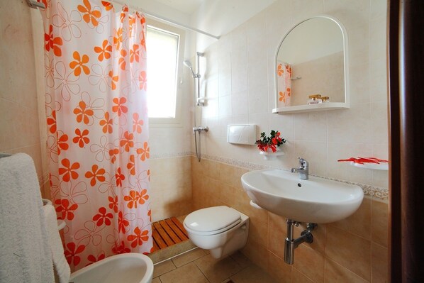A bathroom with a shower, toilet, sink, and a mirror. - Residence Riva Mare Ugento (Ugento)