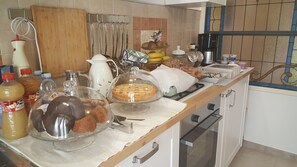 Un bancone della cucina con diversi cibi, una macchina per il caffè e utensili da cucina.