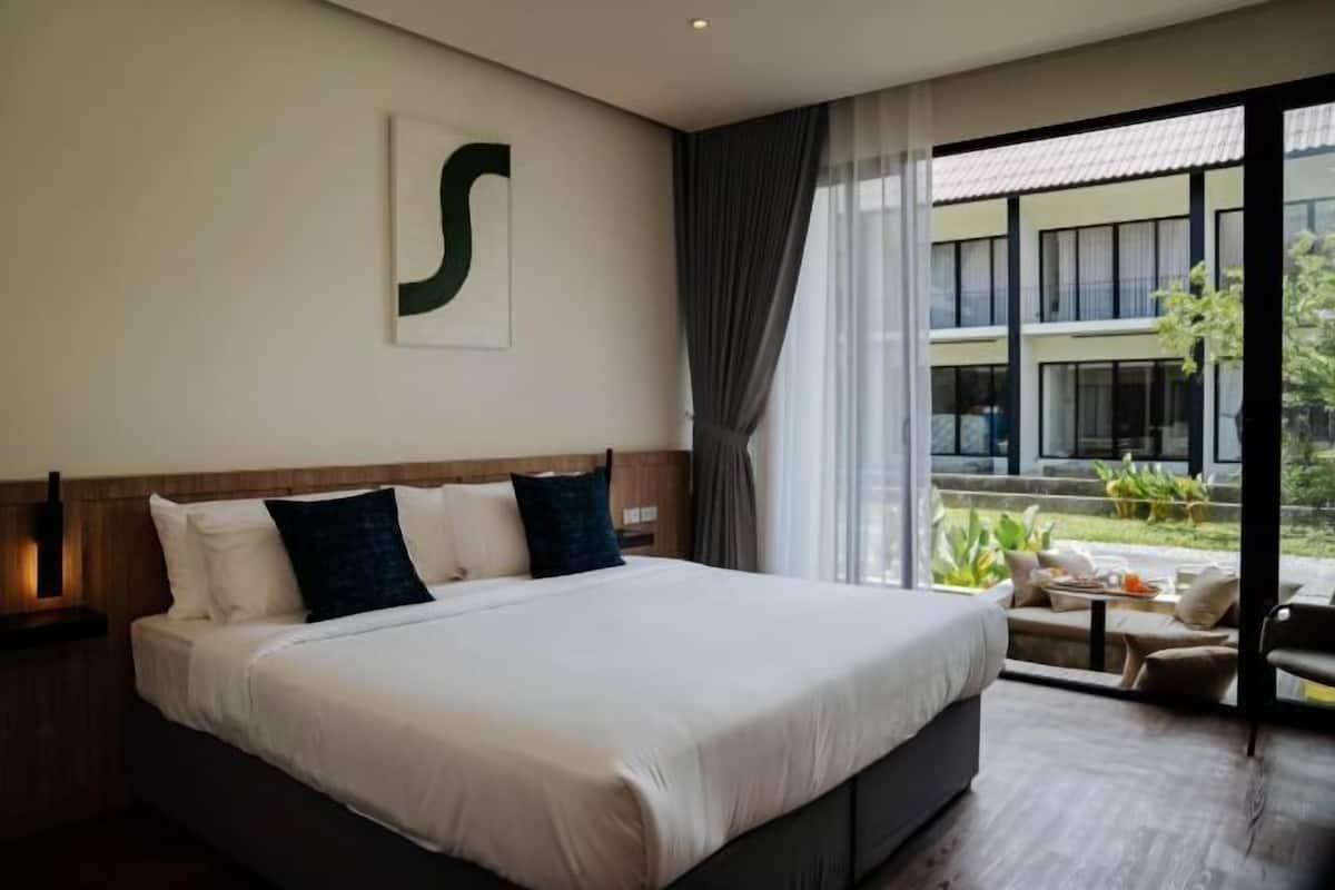 A hotel room with a large bed, a view of the outdoors, and a modern design.
