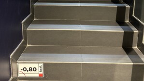 Une série d’escaliers noirs portant des étiquettes indiquant le nombre de calories brûlées en les empruntant.