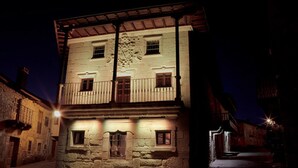 Un edificio histórico con fachada de piedra, varias ventanas y un balcón.