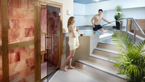 A spa area with a glass door leading to a steam room, a staircase, and a potted plant. - Sporthotel Zum Hohen Eimberg (Willingen)