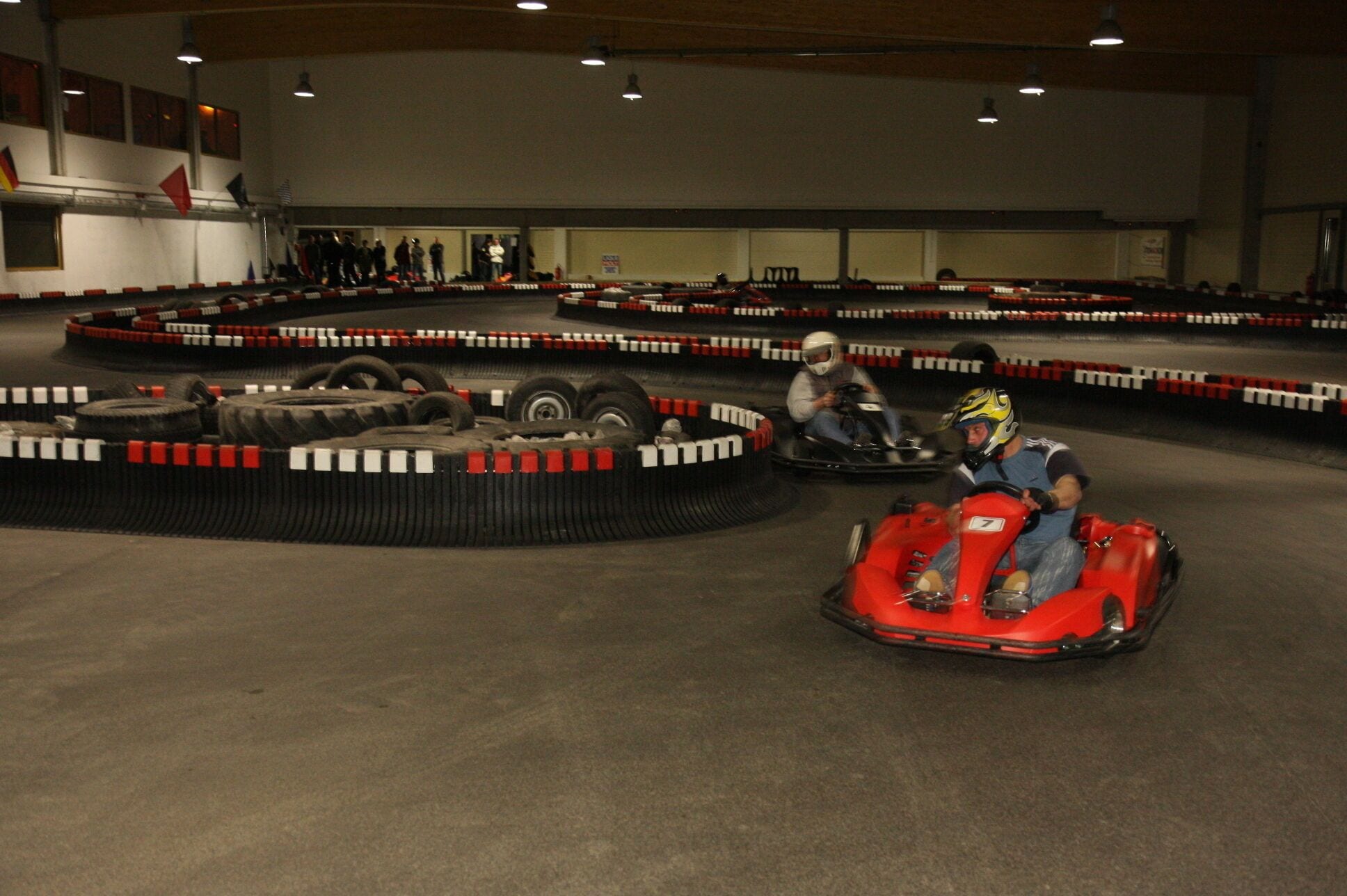 A go-kart track with multiple lanes and a large audience watching.