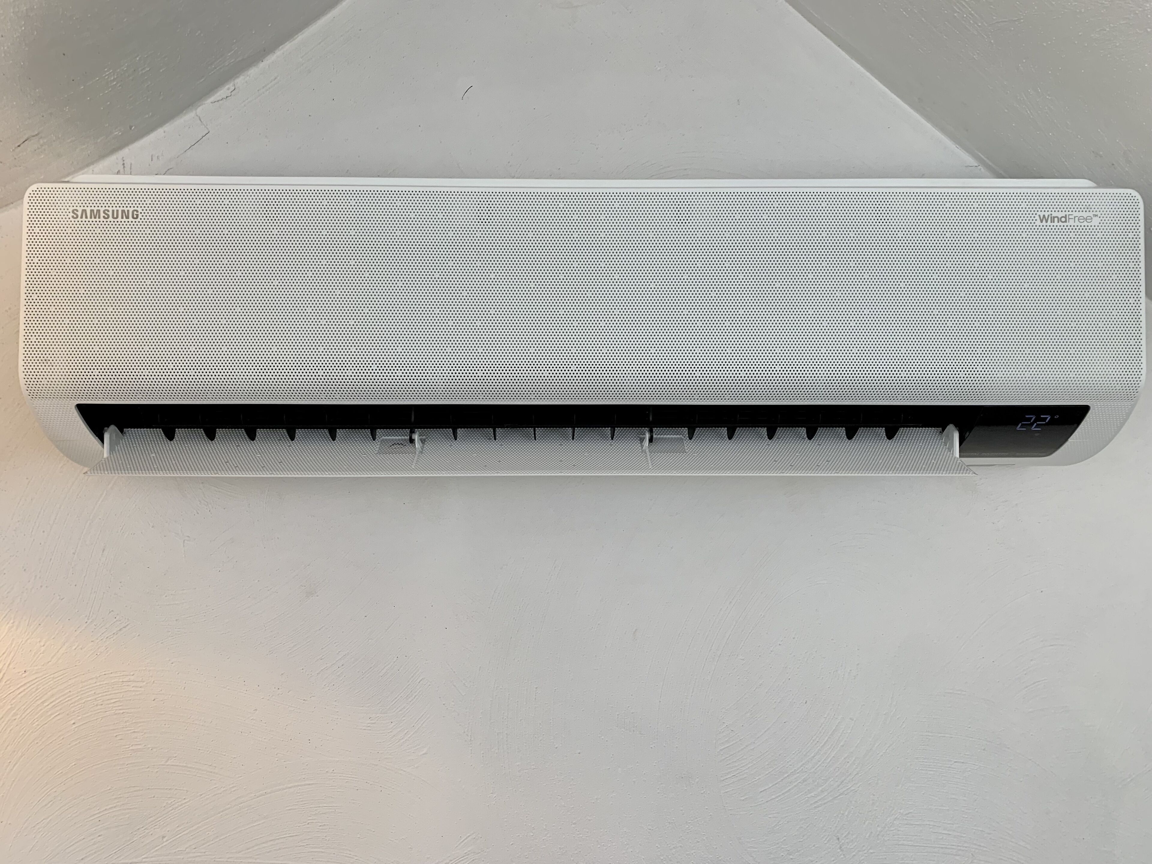 A white wall-mounted air conditioner with a digital display.