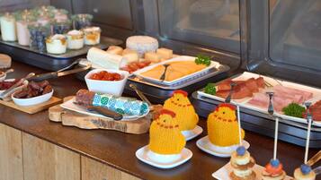 Een buffet met diverse soorten eten, waaronder vleeswaren, kazen en desserts.