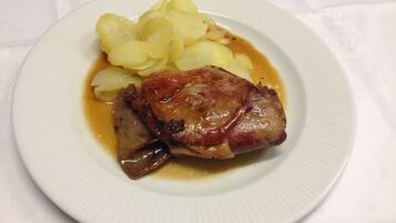 A plate with a piece of meat and potatoes.