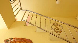 Un escalier avec une rampe en métal et une plaque décorative fixée au mur.