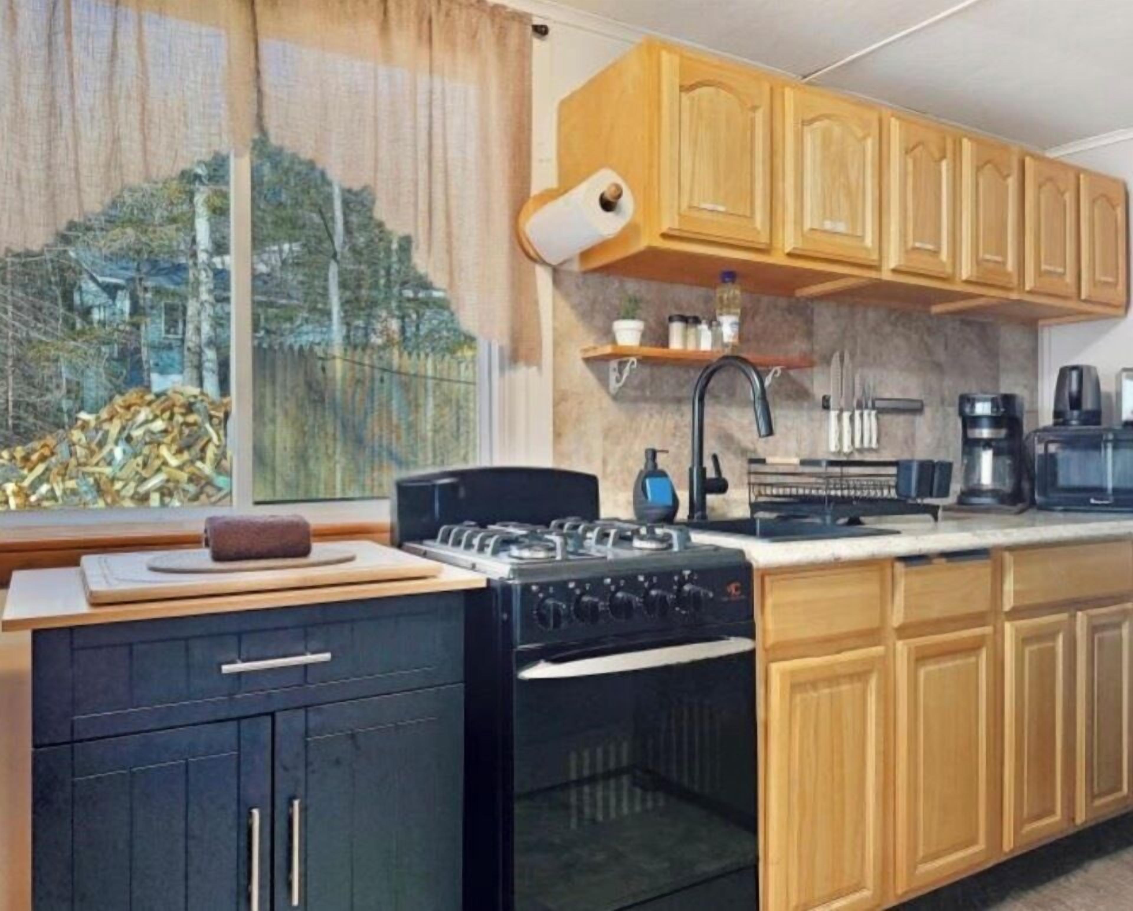 Una cocina con armarios de madera, una estufa y un lavabo.