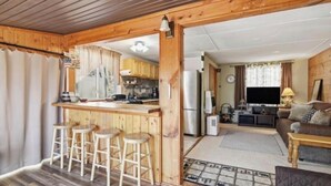 Ein gemütliches Blockhauss-Interieur mit einer Holztresorecke, einer Küche und einem Wohnbereich.