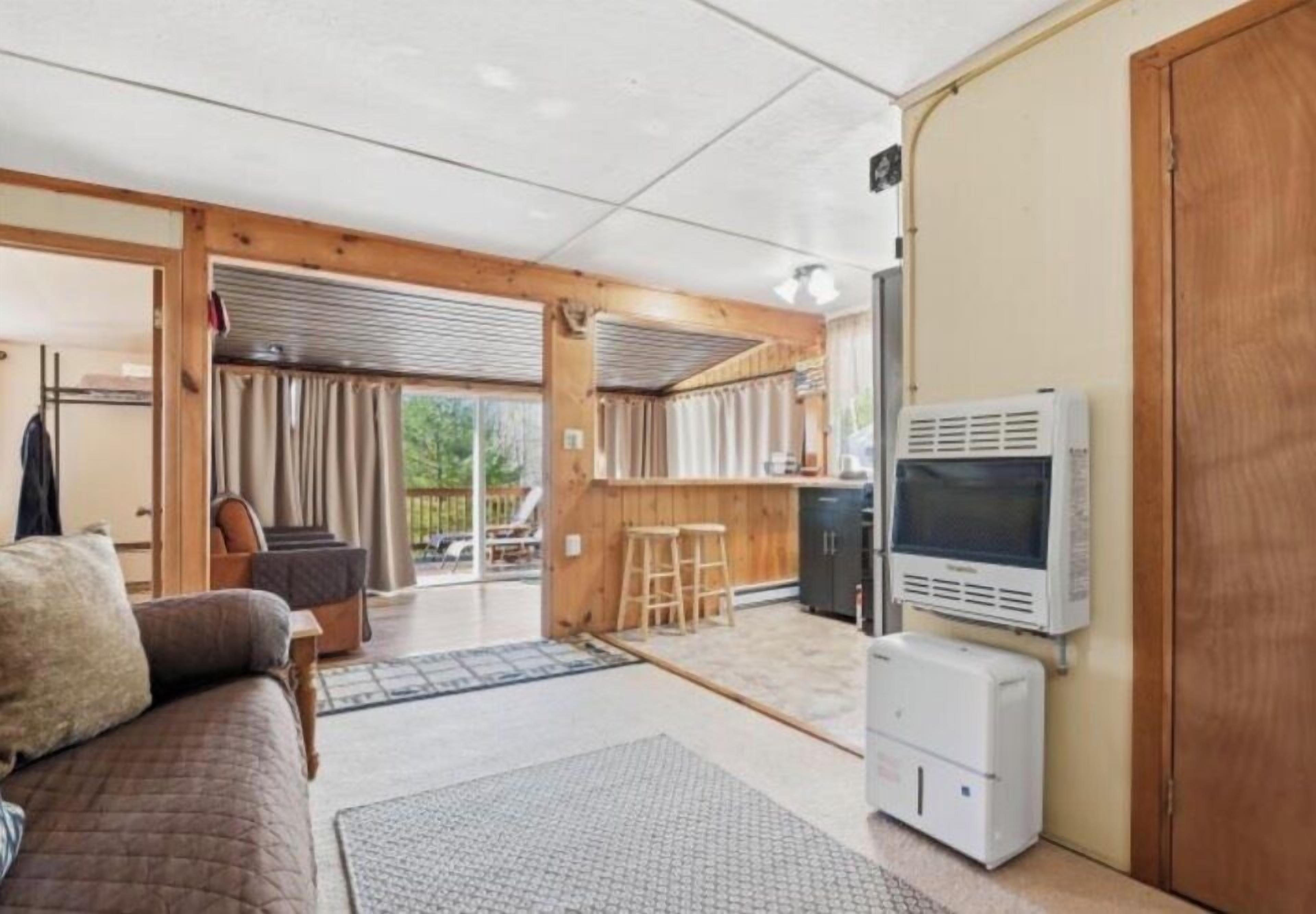 A cozy room with a sofa, a TV, and a kitchenette.