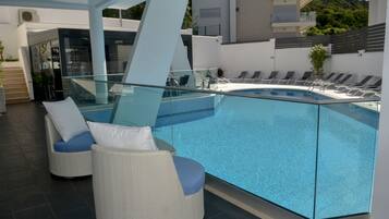 Piscine extérieure, parasols de plage, chaises longues