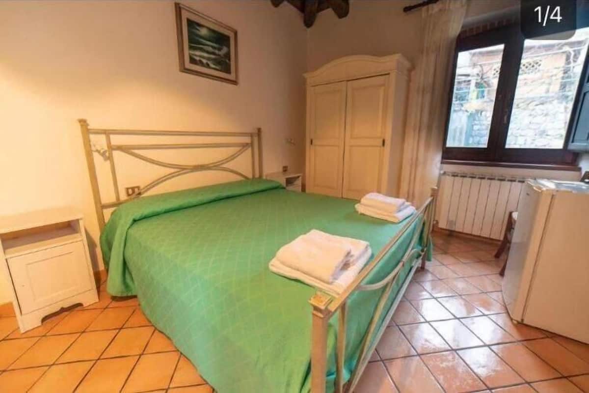 Une chambre à coucher avec un lit, une armoire, un radiateur et une fenêtre.