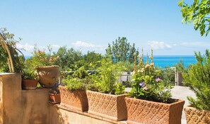 A terrace with potted plants, a view of the sea, and a clear sky. - B&B La Torretta (Maratea)