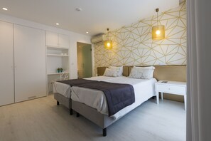 A modern bedroom with a bed, bedside tables, a wardrobe, and geometric wall design.