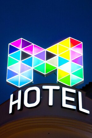 A hotel sign with a colorful geometric logo and the word "HOTEL" below it.